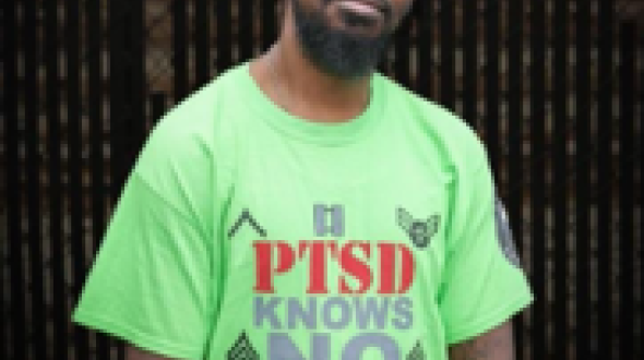 Man wearing green shirt looking at camera smiling