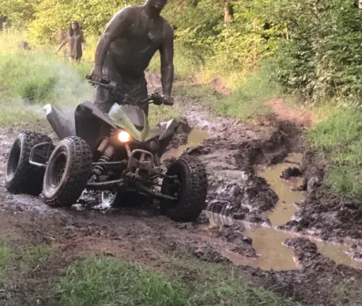 Man on fourwheeler in mud