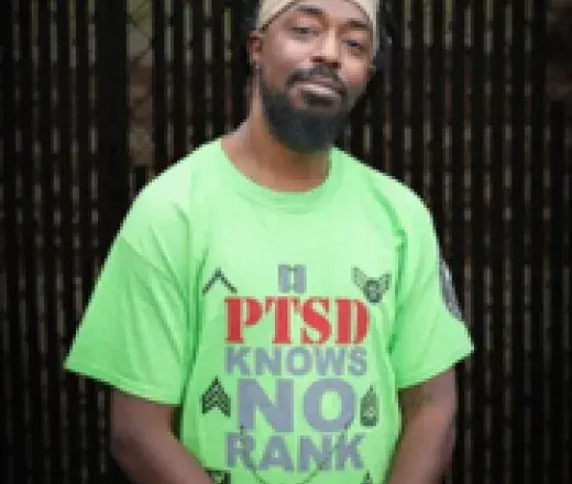 Man wearing green shirt looking at camera smiling