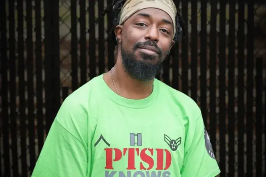 Man in green shirt smiling at camera