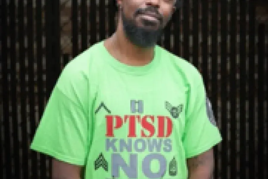 Man wearing green shirt looking at camera smiling